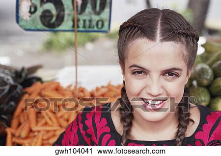 Portrait of a young woman smiling at a market stall View Large Photo Image Stock Image - Portrait of a young woman smiling at a market stall. Fotosearch