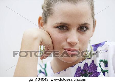 Portrait of a young woman with her hand on her chin View Large Photo Image Stock Image - Portrait of a young woman with her hand on her chin. Fotosearch