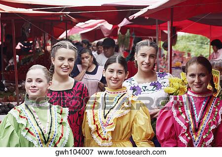 Stock Photo - Portrait of five young women standing in a market smiling. Fotosearch