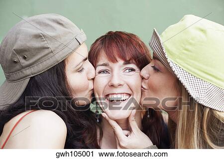 Close-up of a young woman and a mid adult woman kissing a young woman View Large Photo Image Stock Image - Close-up of a young woman and a mid adult woman kissing a young woman. Fotosearch