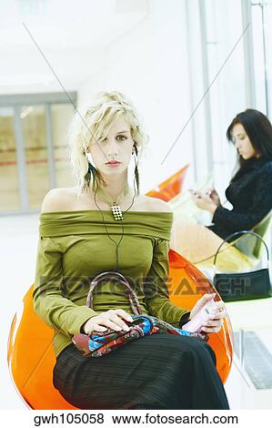 Stock Photo - Portrait of a young woman listening to an MP3 payer. Fotosearch