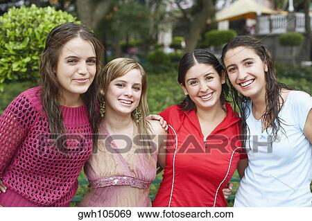 Stock Photo - Portrait of four young women standing together and smiling. Fotosearch