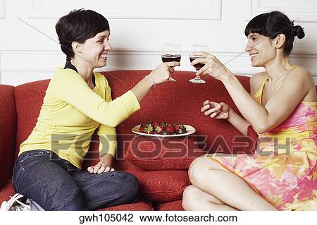 Side profile of two mid adult women toasting with red wine View Large Photo Image Stock Image - Side profile of two mid adult women toasting with red wine. Fotosearch