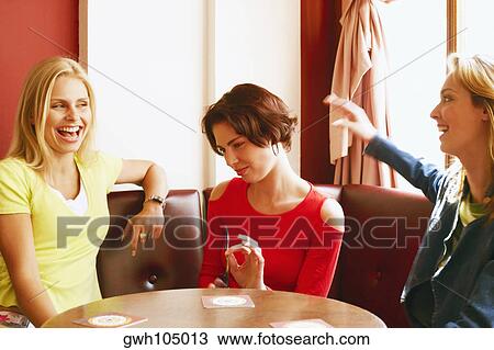 Three young women sitting on a couch View Large Photo Image Stock Image - Three young women sitting on a couch. Fotosearch