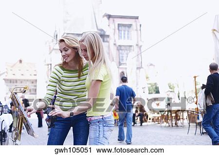 Two young women looking at a menu View Large Photo Image Stock Image - Two young women looking at a menu . Fotosearch