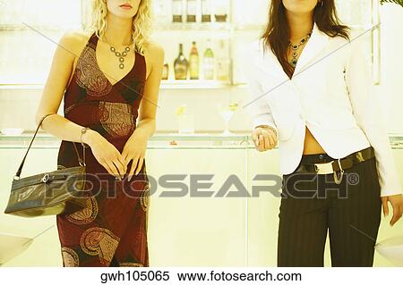 Two young women standing View Large Photo Image Stock Photography - Two young women standing. Fotosearch