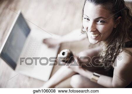 High angle view of a young woman using a laptop View Large Photo Image Stock Photo - High angle view of a young woman using a laptop. Fotosearch