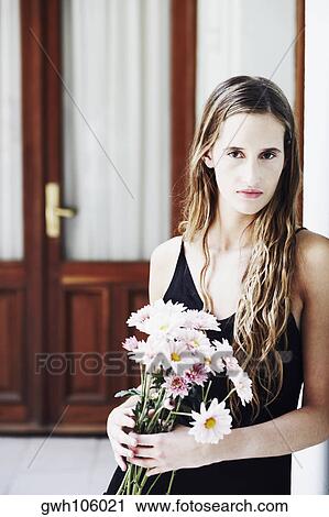 Portrait of a young woman holding a bunch of flowers View Large Photo Image Stock Image - Portrait of a young woman holding a bunch of flowers. Fotosearch