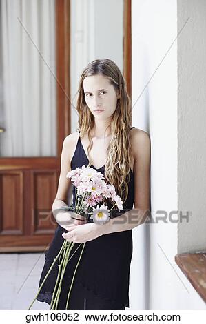 Portrait of a young woman holding a bunch of flowers View Large Photo Image Stock Image - Portrait of a young woman holding a bunch of flowers. Fotosearch