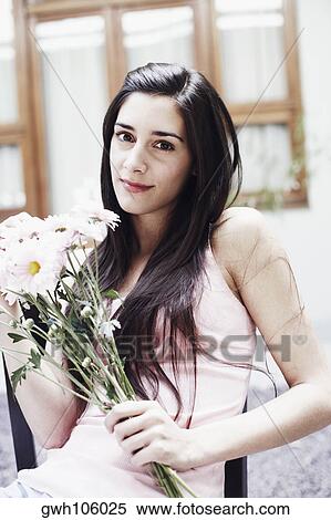 Stock Photography - Portrait of a young woman holding a bunch of flowers. Fotosearch
