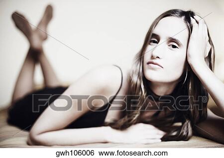 Stock Photograph - Portrait of a young woman lying on the bed. Fotosearch