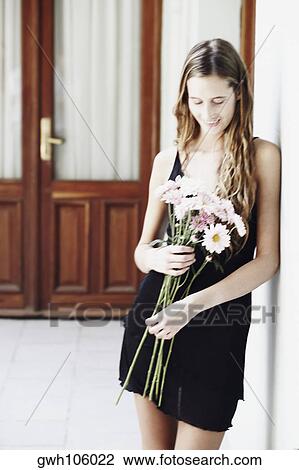 Young woman holding a bunch of flowers and smiling View Large Photo Image Stock Image - Young woman holding a bunch of flowers and smiling. Fotosearch