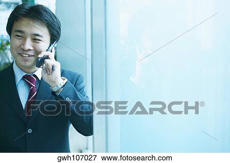 Businessman talking on a mobile phone View Large Photo Image Stock Photo - Businessman talking on a mobile phone. Fotosearch