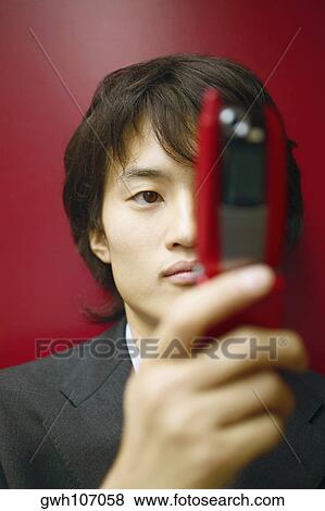 Close-up of a businessman holding a mobile phone View Large Photo Image Stock Photo - Close-up of a businessman holding a mobile phone. Fotosearch