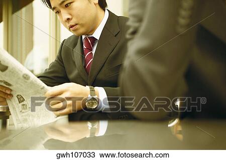 Close-up of a businessman reading a newspaper View Large Photo Image Stock Image - Close-up of a businessman reading a newspaper. Fotosearch