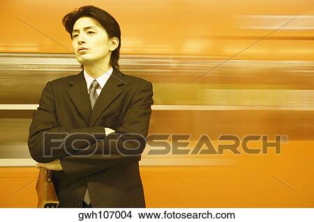 Close-up of a businessman standing with his arms folded View Large Photo Image Picture - Close-up of a businessman standing with his arms folded. Fotosearch