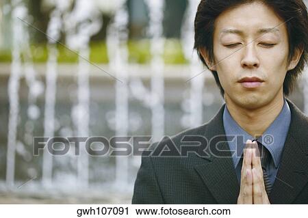 Close-up of a young man praying View Large Photo Image Stock Image - Close-up of a young man praying. Fotosearch