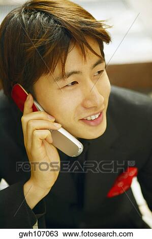 Close-up of a young man talking on a mobile phone View Large Photo Image Stock Image - Close-up of a young man talking on a mobile phone. Fotosearch