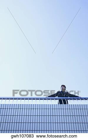 Low angle view of a businessman wearing a headset View Large Photo Image Stock Image - Low angle view of a businessman wearing a headset . Fotosearch