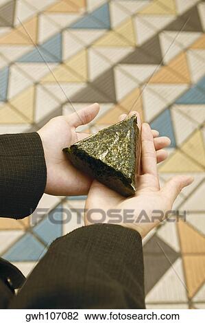 Stock Image - Person holding a triangular shaped leaf. Fotosearch