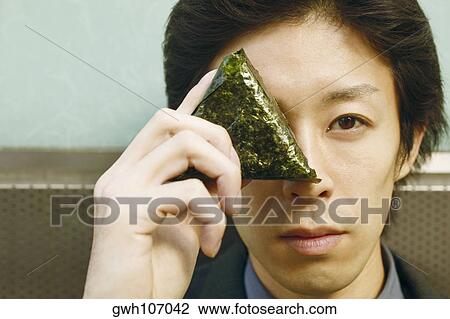 Portrait of a businessman covering his eye with a triangular shaped leaf View Large Photo Image Stock Image - Portrait of a businessman covering his eye with a triangular shaped leaf. Fotosearch