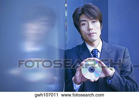 Portrait of a businessman holding a CD View Large Photo Image Stock Image - Portrait of a businessman holding a CD. Fotosearch