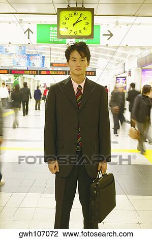 Portrait of a businessman holding a briefcase standing in an airport View Large Photo Image Stock Image - Portrait of a businessman holding a briefcase standing in an airport . Fotosearch