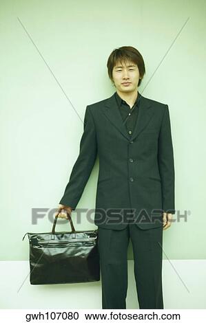 Stock Image - Portrait of a businessman holding a briefcase. Fotosearch