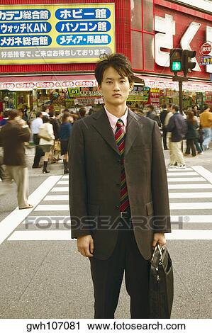 Portrait of a businessman holding a briefcase standing on the road View Large Photo Image Stock Image - Portrait of a businessman holding a briefcase standing on the road . Fotosearch