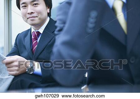 Portrait of a businessman holding a newspaper View Large Photo Image Stock Photo - Portrait of a businessman holding a newspaper. Fotosearch