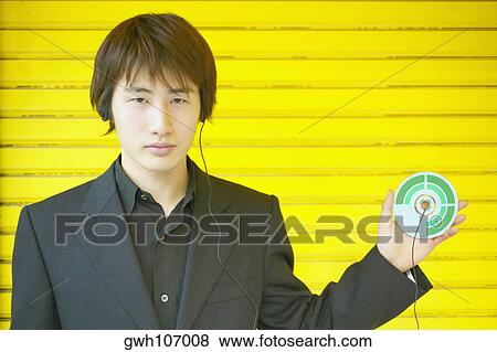 Stock Photo - Portrait of a young man holding a CD. Fotosearch