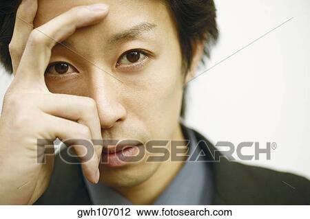Portrait of a young man with his hand on his head View Large Photo Image Stock Image - Portrait of a young man with his hand on his head. Fotosearch