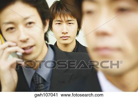 Stock Image - Portrait of three businessmen one behind the other. Fotosearch