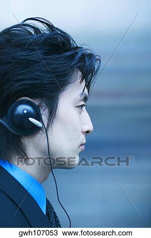 Side profile of a businessman wearing headphones View Large Photo Image Stock Image - Side profile of a businessman wearing headphones. Fotosearch