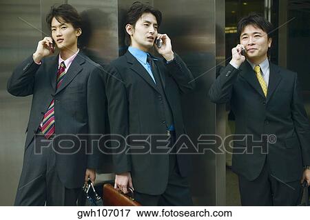 Stock Photo - Three businessmen talking on mobile phones . Fotosearch