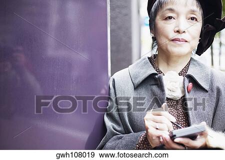 Close-up of a mature woman holding a personal data assistant View Large Photo Image Stock Photo - Close-up of a mature woman holding a personal data assistant. Fotosearch