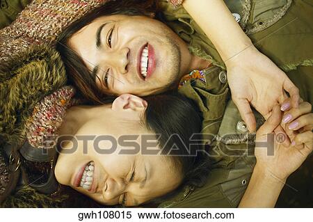 Stock Photography - High angle view of a young woman and a mid adult man smiling. Fotosearch