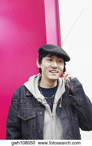 Stock Image - Mid adult man talking on a mobile phone. Fotosearch
