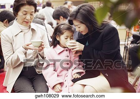 Mid adult woman feeding her daughter View Large Photo Image Stock Photo - Mid adult woman feeding her daughter . Fotosearch