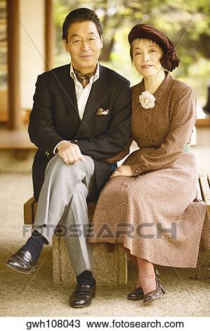 Stock Image - Portrait of a senior man and a mature woman sitting together . Fotosearch