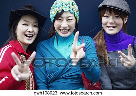 Portrait of three young women making the peace sign View Large Photo Image Stock Image - Portrait of three young women making the peace sign. Fotosearch