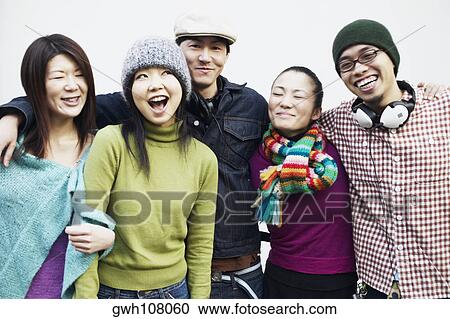 Stock Image - Portrait of two mid adult men and three young women smiling. Fotosearch