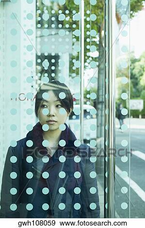 Young Woman Standing Behind A Glass Door Stock Photo Gwh108059