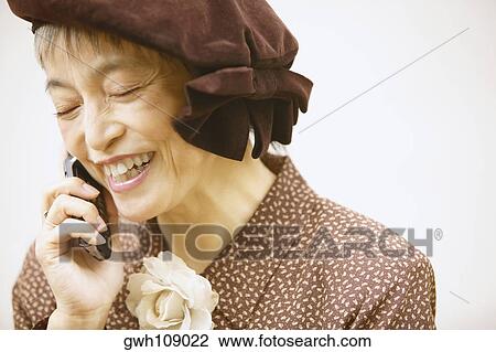 Stock Image - Close-up of a mature woman talking on a mobile phone. Fotosearch
