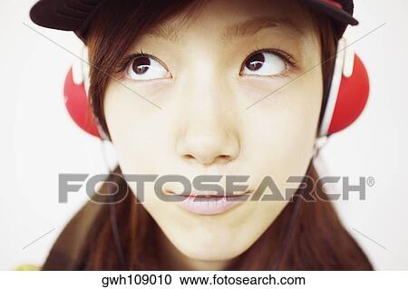 Stock Image - Close-up of a young woman wearing headphones. Fotosearch