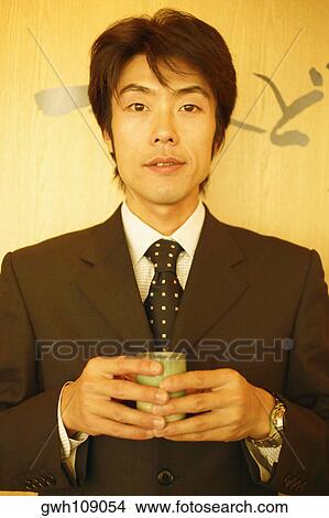 Portrait of a mid adult man holding a cup View Large Photo Image Picture - Portrait of a mid adult man holding a cup. Fotosearch
