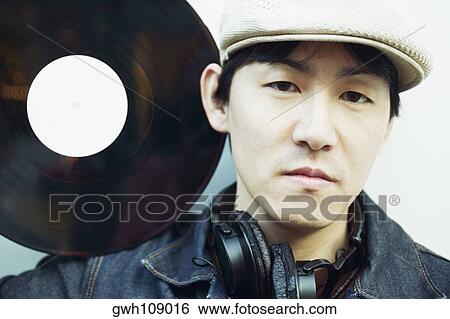 Stock Photograph - Portrait of a mid adult man holding a record on his shoulder. Fotosearch