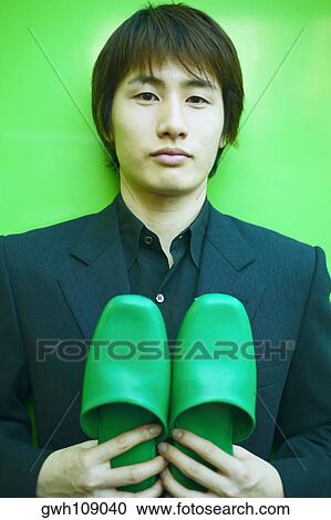 Portrait of a young man holding a pair of sandals View Large Photo Image Stock Image - Portrait of a young man holding a pair of sandals. Fotosearch