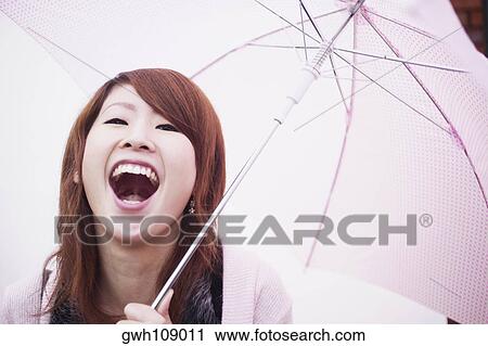 Portrait of a young woman laughing under an umbrella View Large Photo Image Stock Image - Portrait of a young woman laughing under an umbrella. Fotosearch