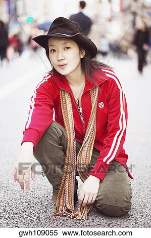 Portrait of a young woman squatting on the street View Large Photo Image Stock Photography - Portrait of a young woman squatting on the street . Fotosearch